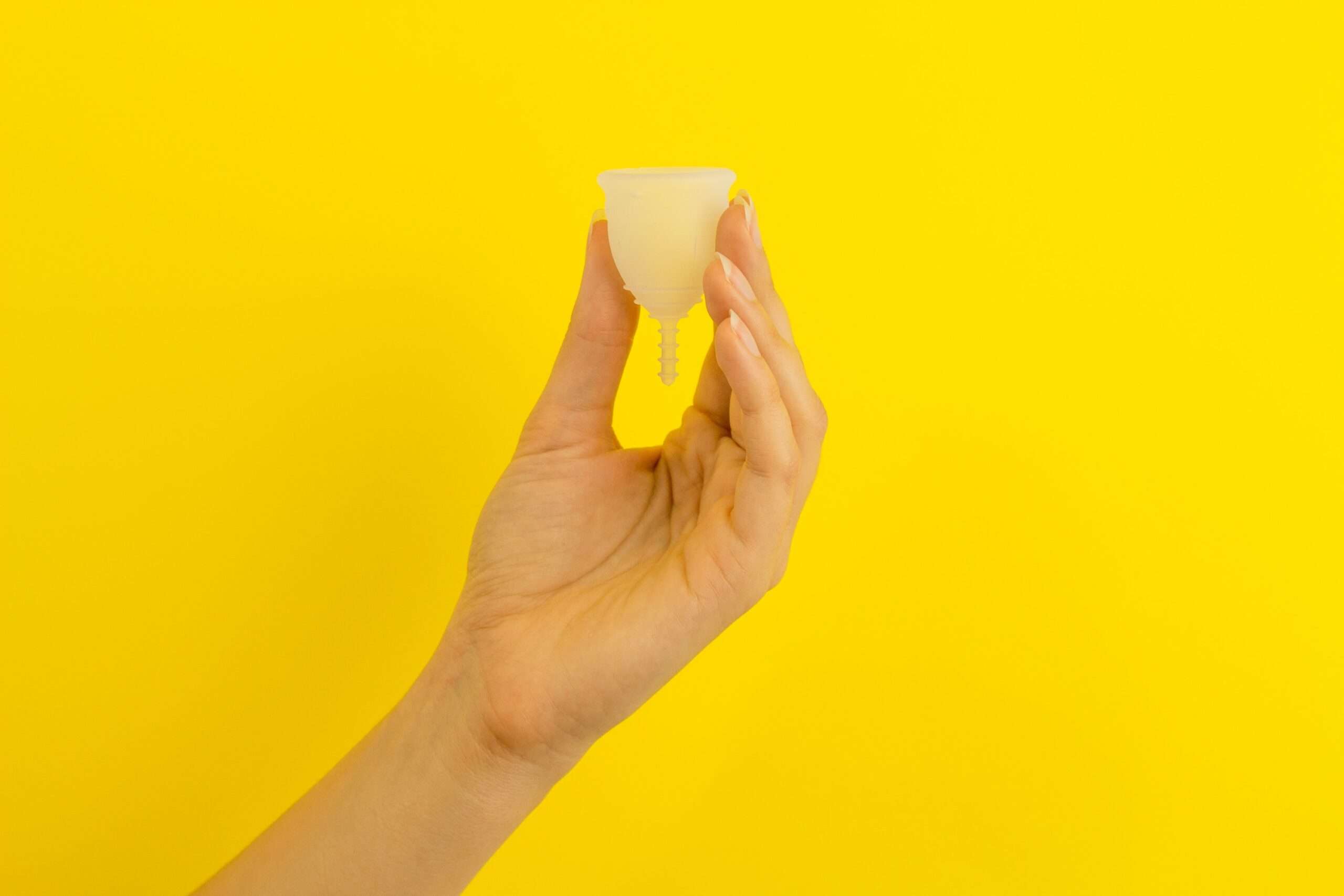 Eine Hand, die eine Menstruationtasse hält