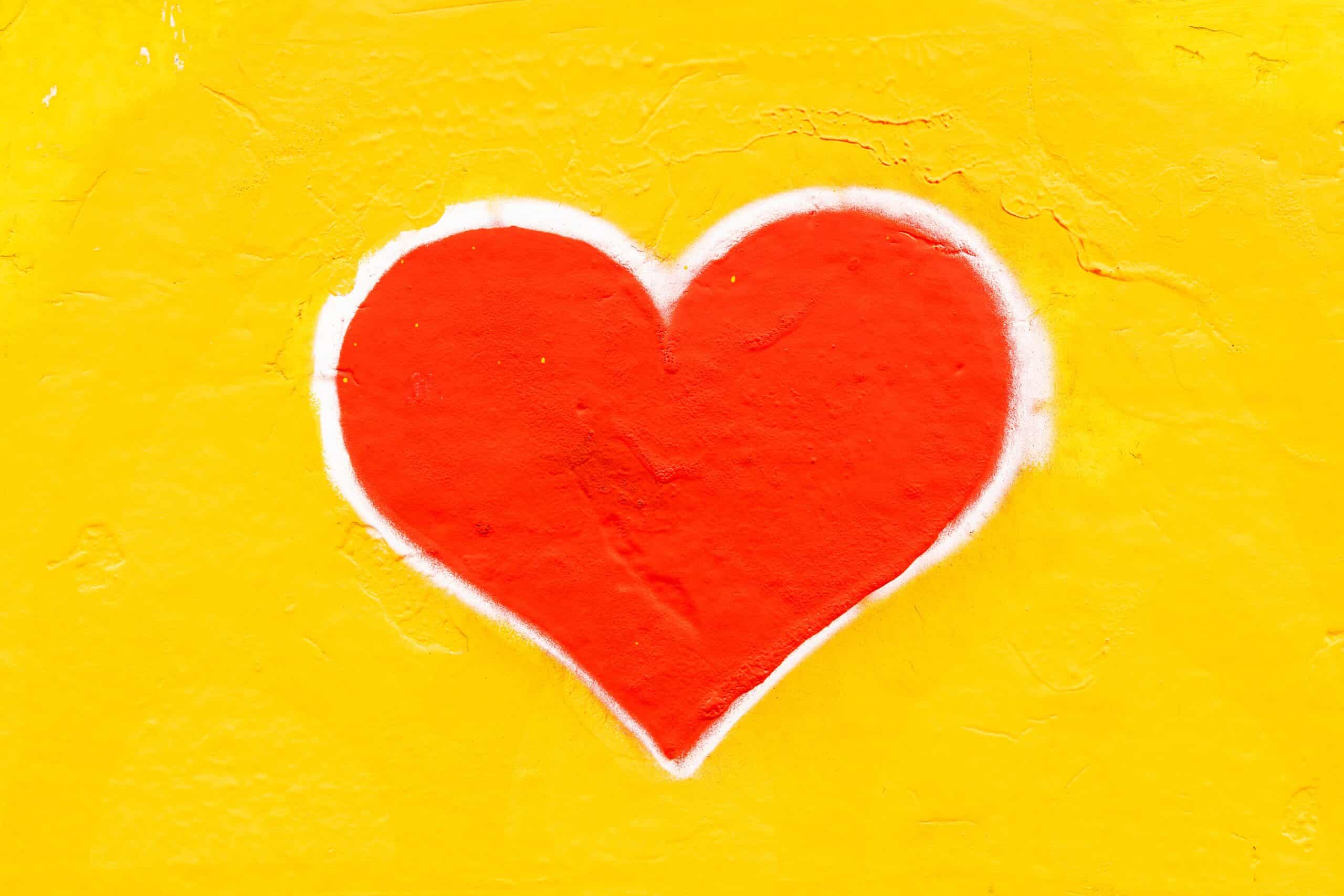 Ein rotes Herz gemalt auf gelbem Hintergrund