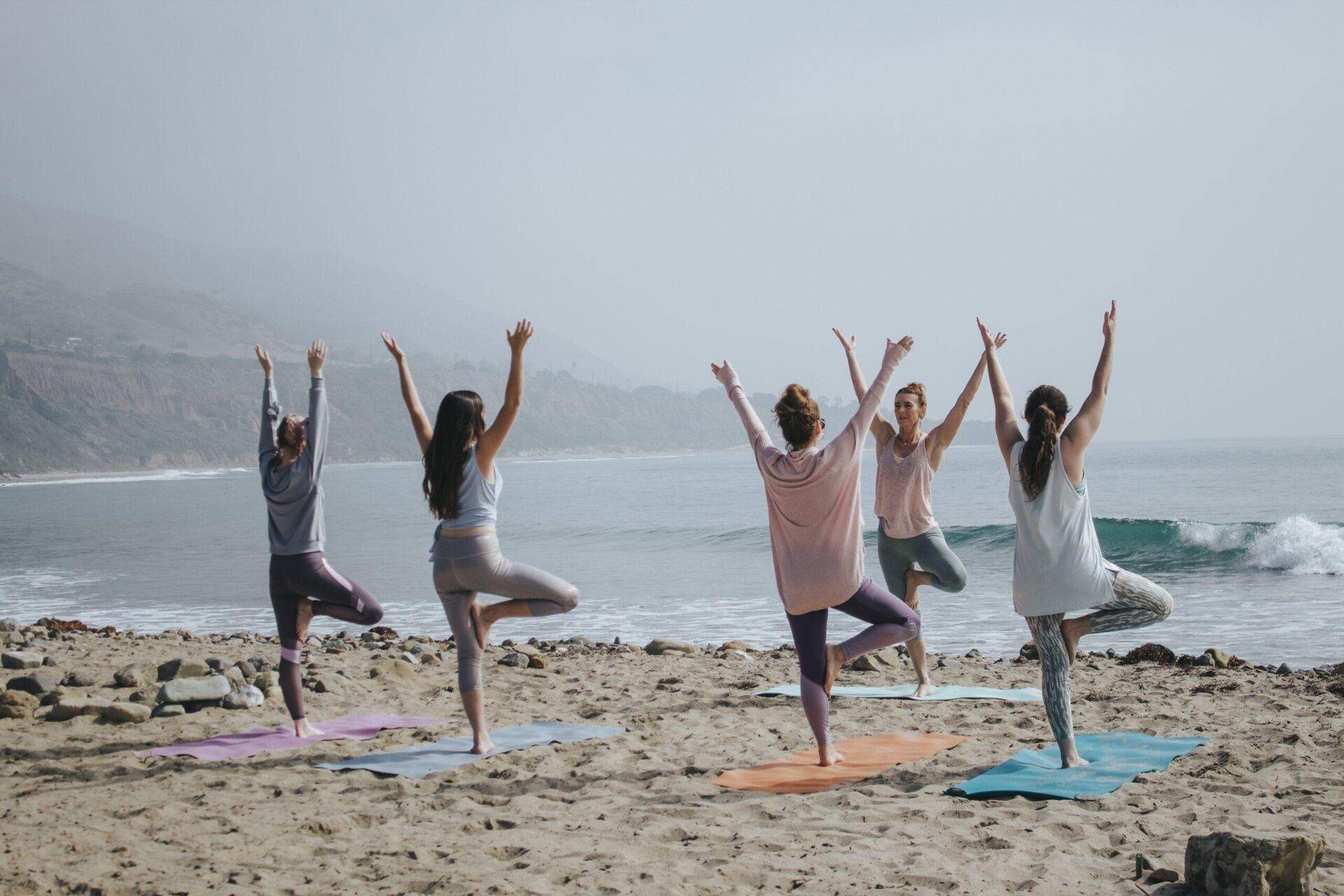 Gruppe macht am Strand Yoga