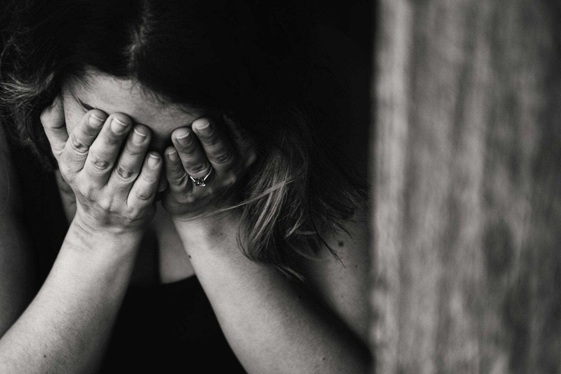 eine Person, die die Hände vor das Gesicht geschlagen hat