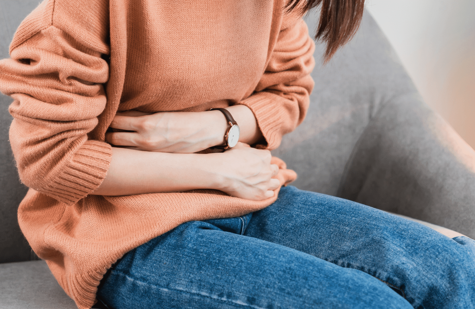 Person, die sich ihren Bauch hält