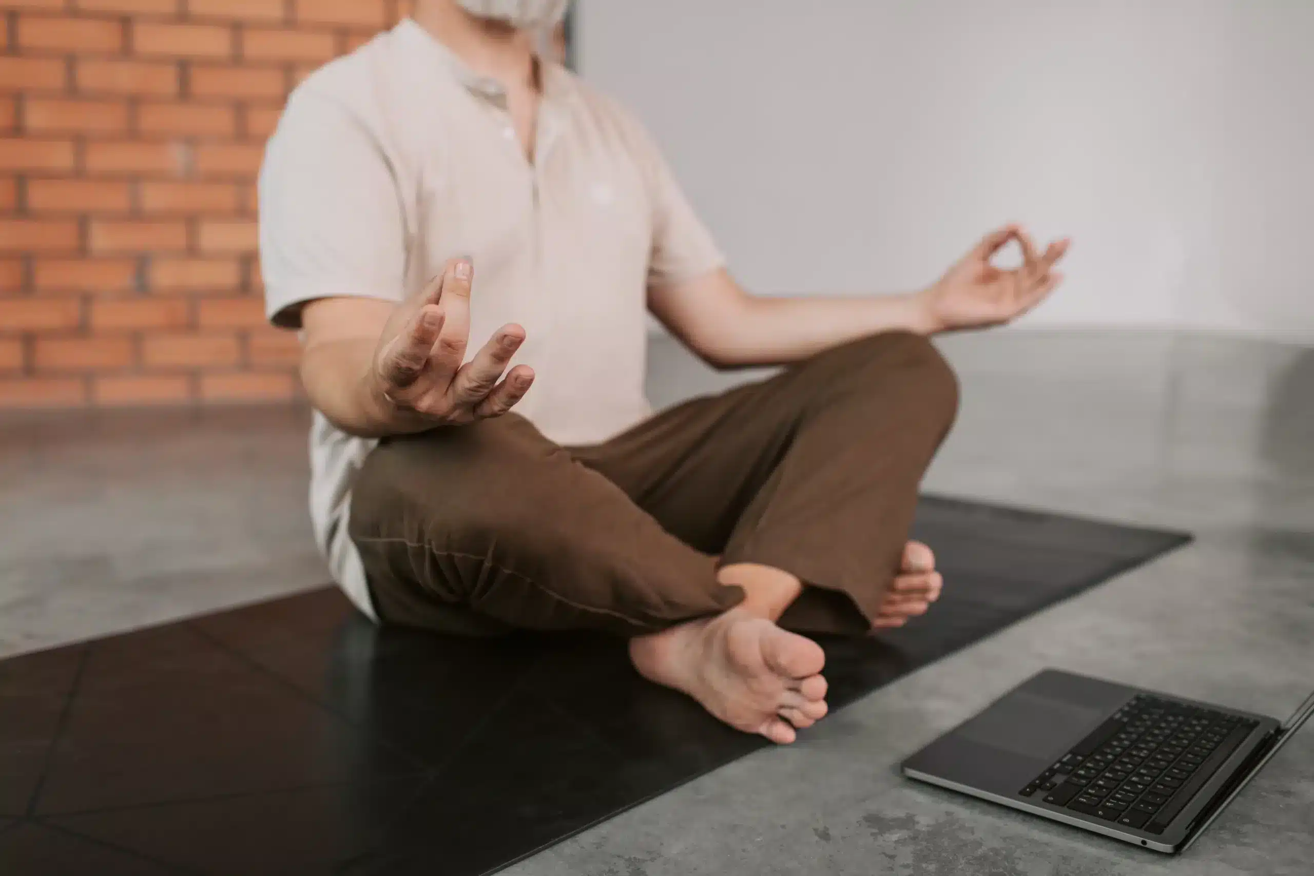 Mensch, der vor dem Laptop meditiert