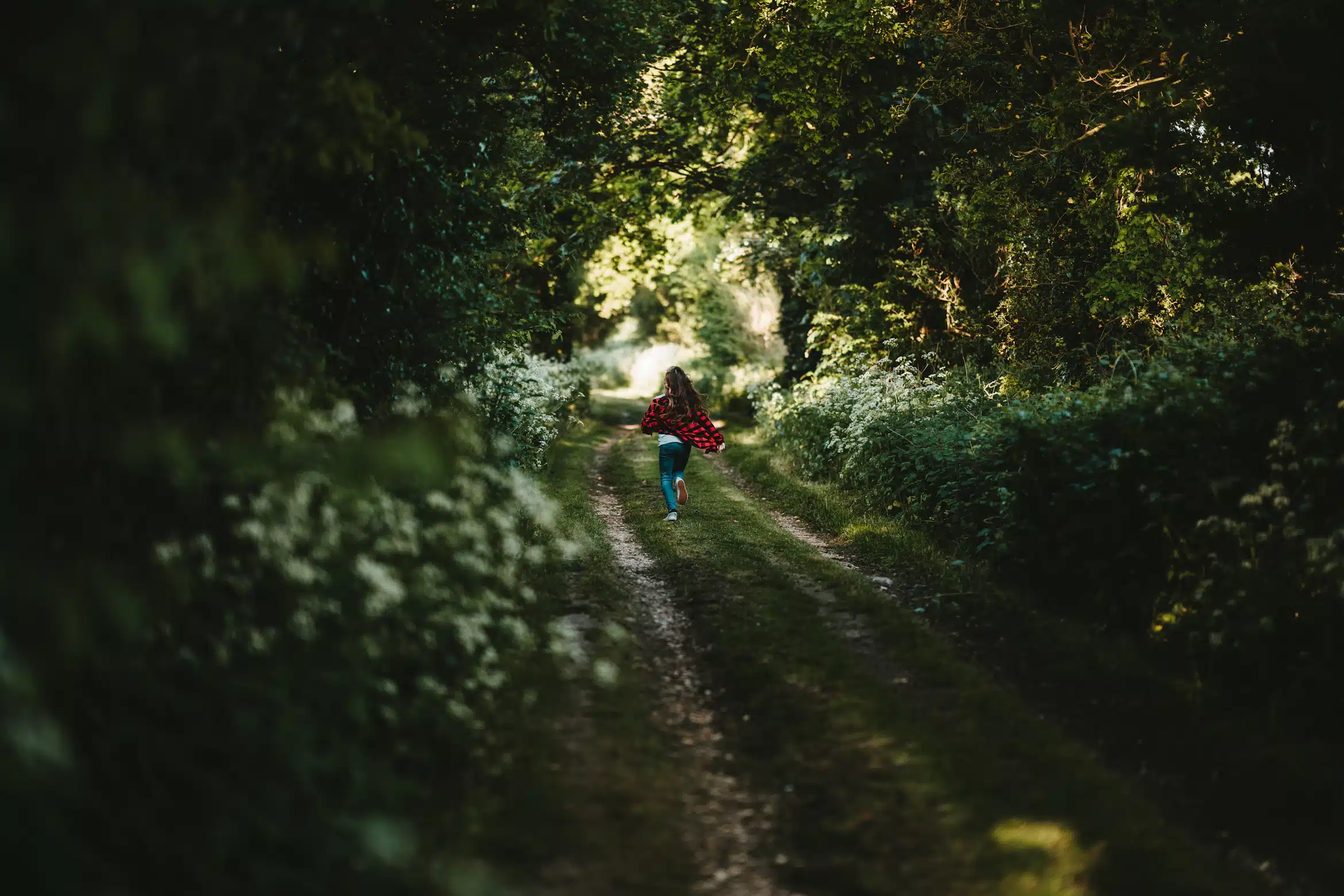 Kind, das durch einen Wald läuft als Sinnbild für das innere Kind