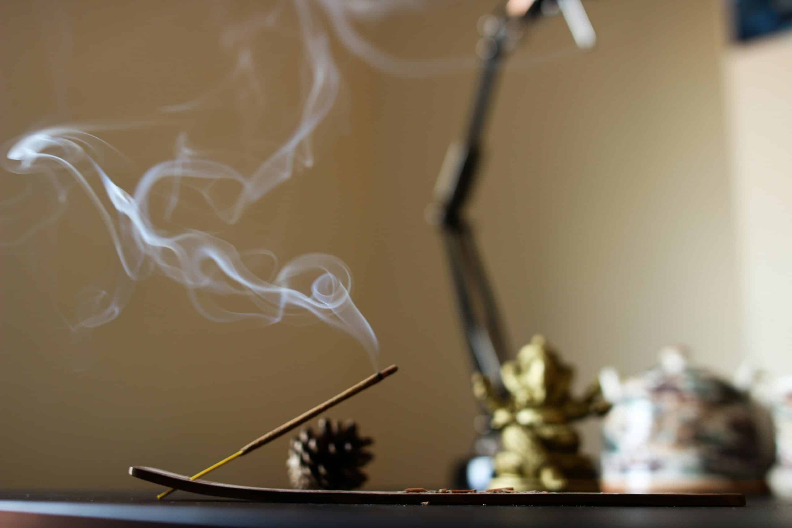 Ein angezündetes Räucherstäbchen als Sinnbild für Yoga und Meditation