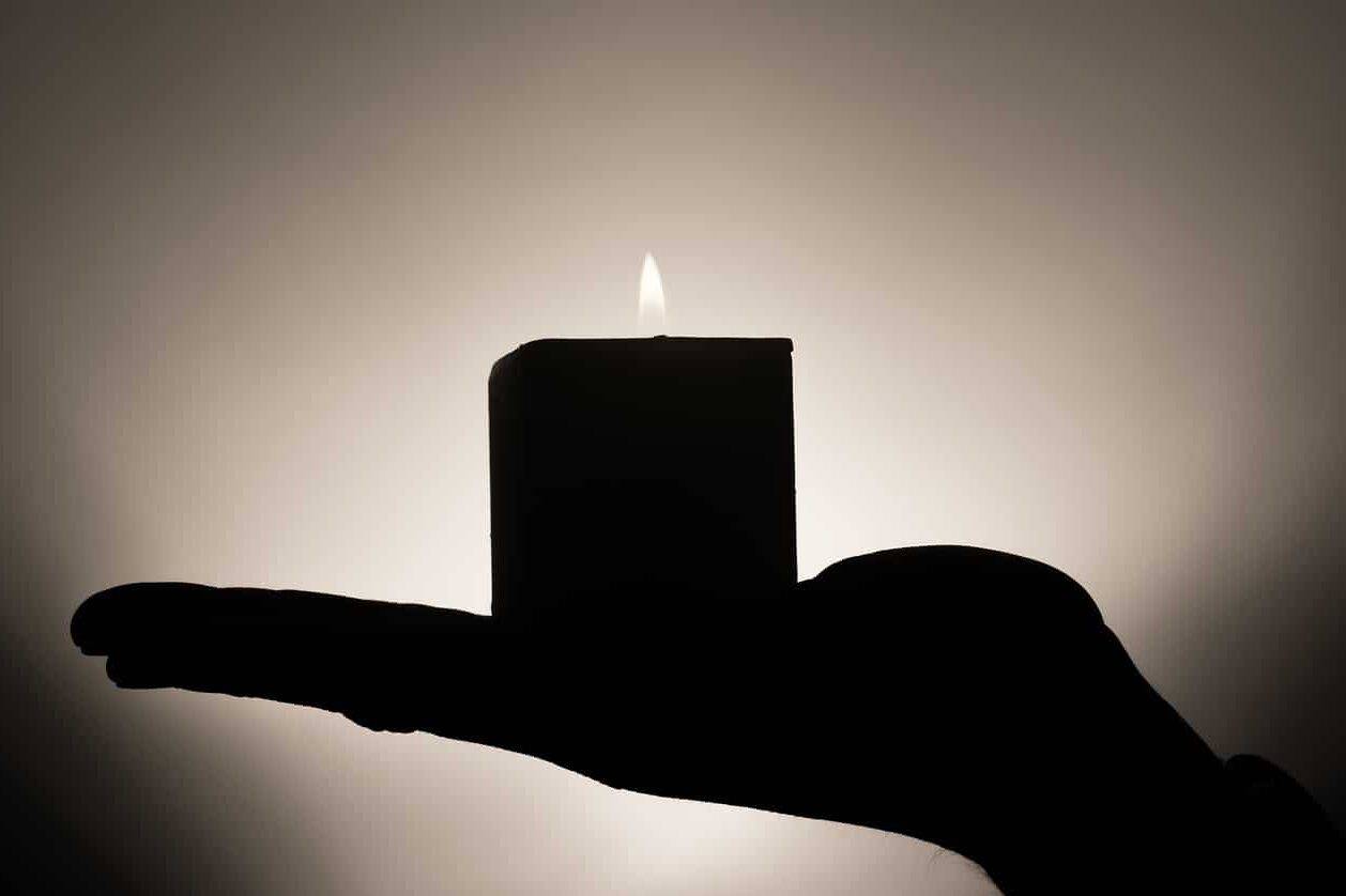 Meditation symbolisiert als Kerze die auf einer Hand steht