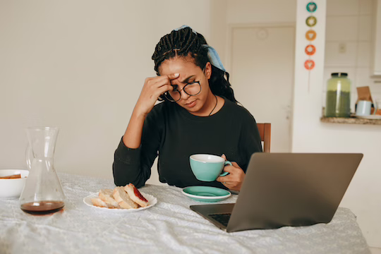 Frau, die gestresst vor dem Laptop sitzt