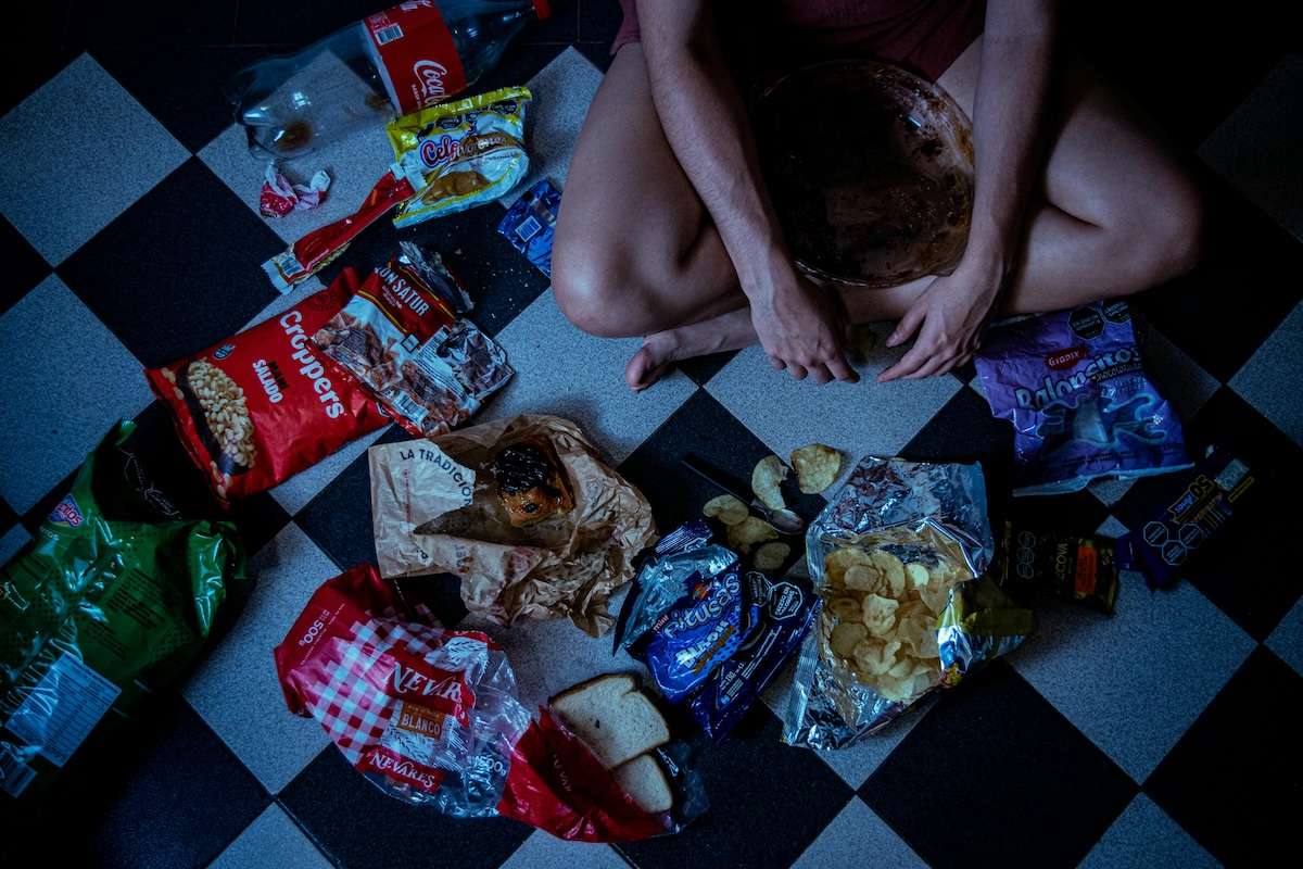 Frau, die zwischen ganz viel Snacks sitzt